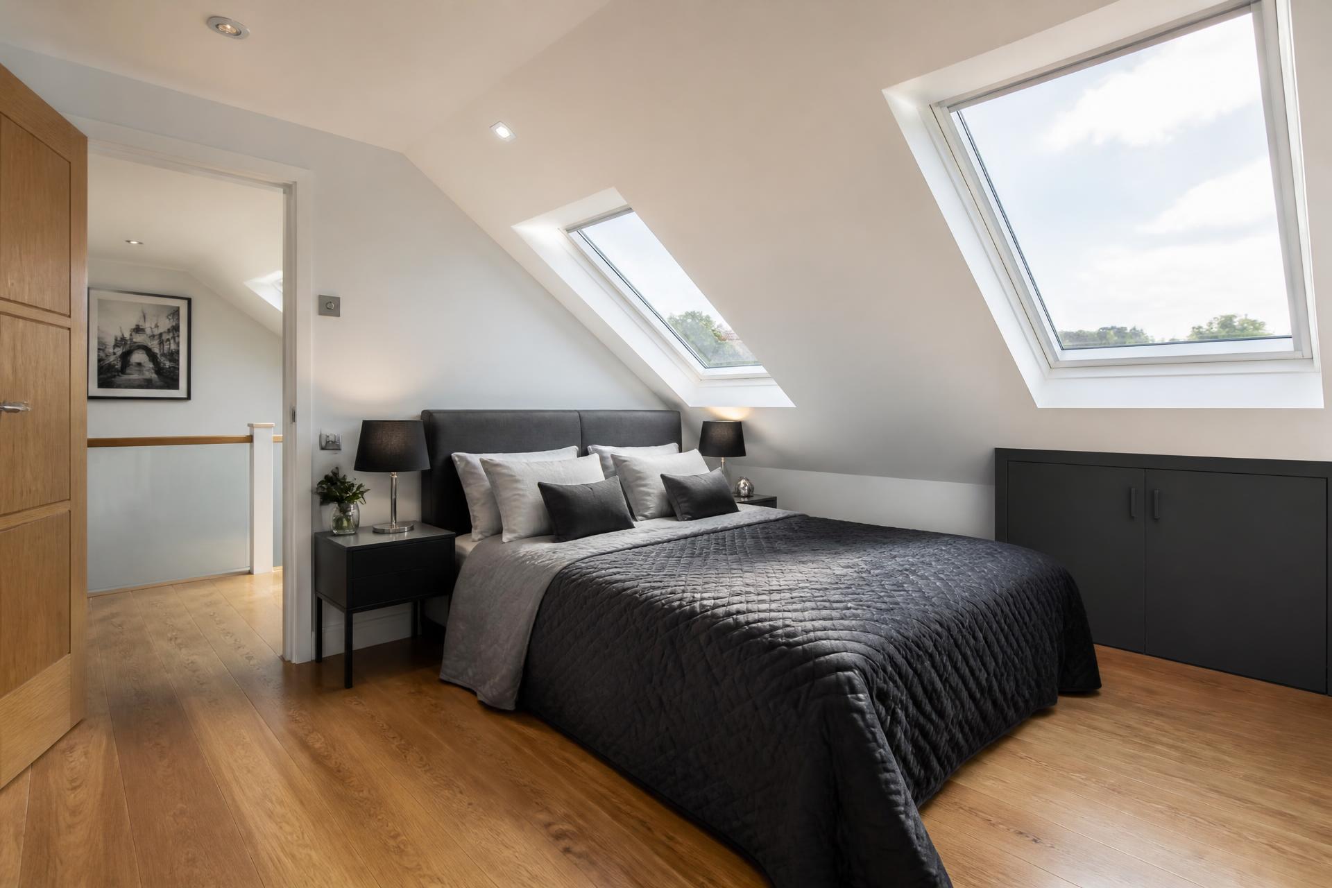 Completed loft conversion bedroom with skylights and oak flooring in a London home